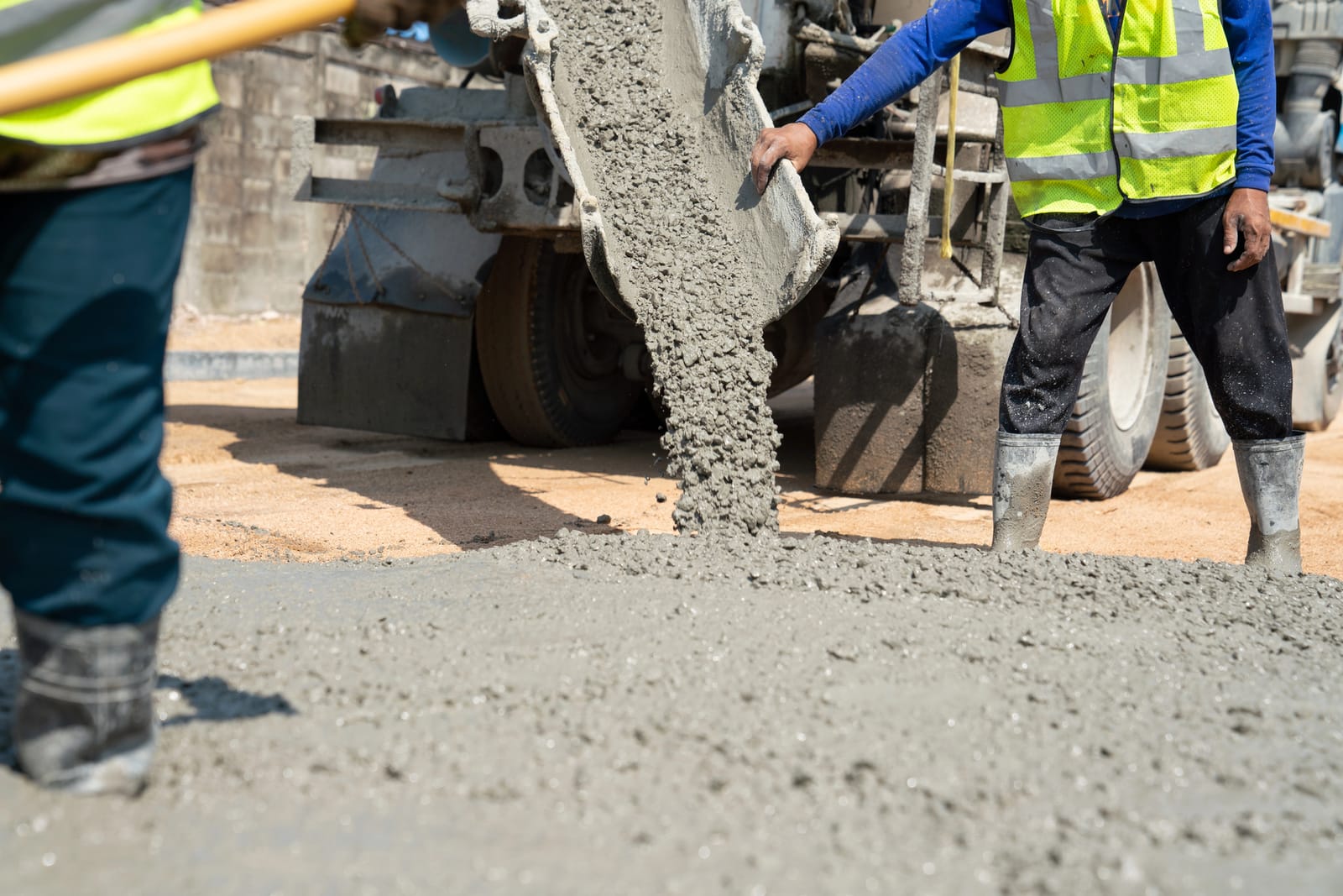 Wylewanie betonu towarowego z rynny betonomieszarki na placu budowy — dostawa gotowej mieszanki betonowej na fundament